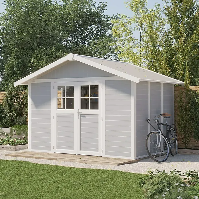 Grosfillex Gerätehaus Deco H7,5 - Außenmaß inkl. Dachüberstand (B x T): 370 x 298 cm, Kunststoff, Lichtgrau, 7,5 m² - Ein graues Gartenhaus mit weißen Akzenten, flankiert von einem Fahrrad, bietet praktischen Stauraum im Garten.