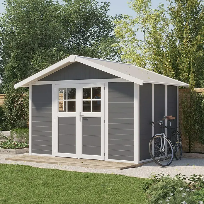 Grosfillex Gerätehaus Deco H7,5 - Außenmaß inkl. Dachüberstand (B x T): 370 x 298 cm, Kunststoff, Dunkelgrau, 7,5 m² - Ein graues Gartenhaus mit weißem Rahmen und Doppeltür steht neben einem Fahrrad.