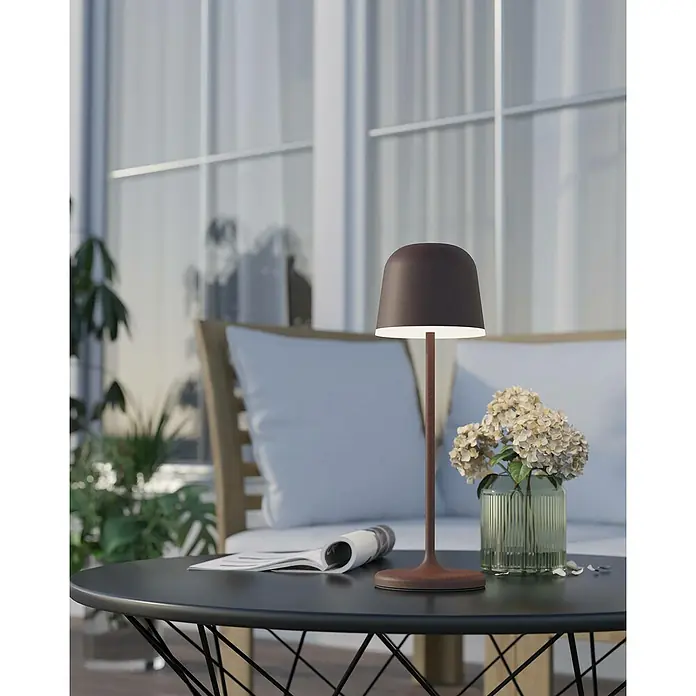Eglo Tischleuchte Mannera - Durchmesser: 11 cm, Höhe: 34 cm, 2,2 W - Elegante braune Tischleuchte auf einem schwarzen Tisch mit Blumen und einer Zeitung. Die Lampe sorgt für warmes Licht.