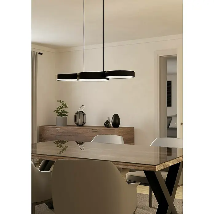Eglo Connect LED-Pendelleuchte Barbano-Z - 7,5 W, L x B x H: 82 x 30 x 110 cm, Schwarz, RGBW - Eine moderne, schwarze Hängeleuchte mit drei runden Lampenschirmen hängt über einem eleganten Esstisch mit Stühlen.