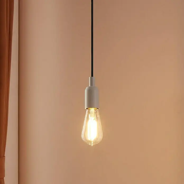 Eglo connect.z Smart-LED-Lampe ST64 - E27, Dimmbar, Warmweiß, 806 lm, 6 W - Nahaufnahme einer Pendelleuchte mit einer Edison-Glühbirne, die ein warmes, einladendes Licht ausstrahlt, vor einem schlichten Hintergrund.