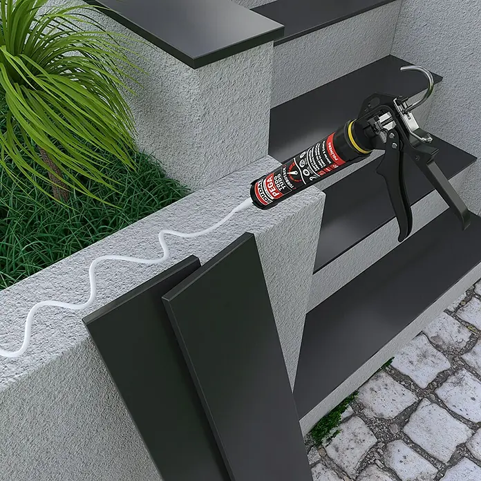 Soudal Adhesivo para montaje Pega Todo Turbotack - 290 ml, Cartucho - Imagen de una pistola de cartuchos con adhesivo blanco, colocada sobre una superficie de hormigón. El producto es ideal para la adhesión de materiales.