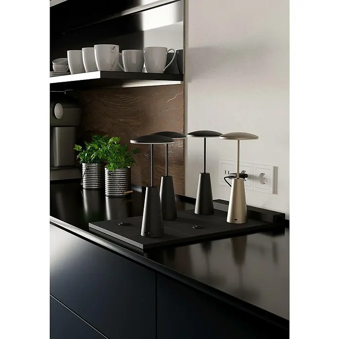 Eglo Ladegerät Multi Charging - Schwarz, Passend für bis zu sechs Akkutischleuchten - Elegante kabellose Tischleuchten in Schwarz und Gold auf einer Küchentheke, die modernes Design und Funktionalität vereinen.