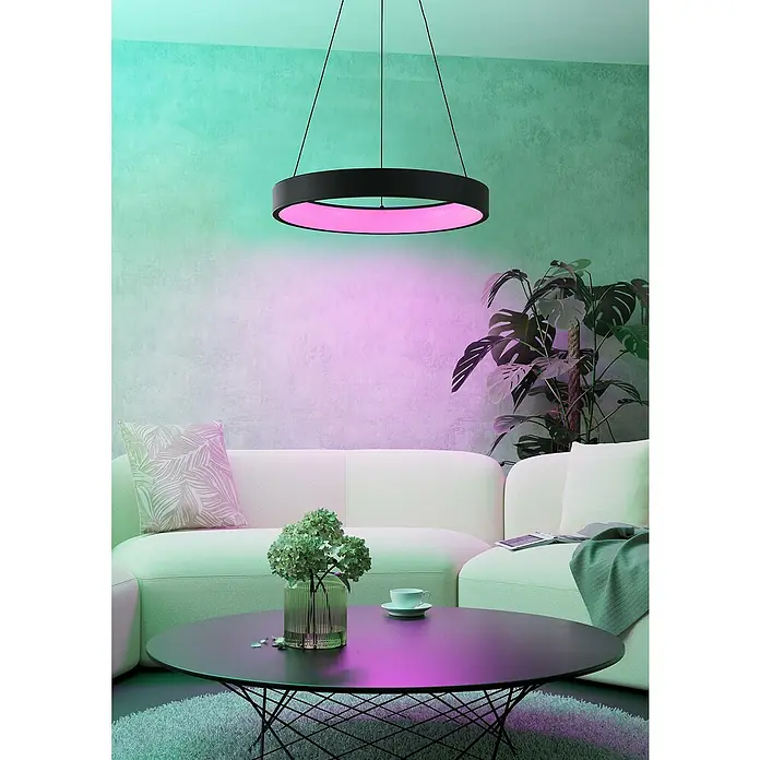 Eglo LED-Pendelleuchte rund Marghera-Z - Ø x H: 60 x 110 cm, Neutralweiß - Ein modernes Wohnzimmer mit einer runden Hängelampe, die rosa Licht ausstrahlt, über einem Couchtisch und einer Couch.