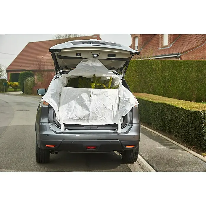 Mottez Transporttasche - L x B x H: 140 x 100 x 80 cm, Schutz gegen: Beschädigungen - Ein graues Auto mit geöffneter Heckklappe und einer weißen Plane, die einen Weihnachtsbaum schützt, steht auf einer Straße.