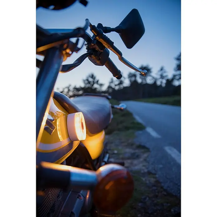 Luz de emergencia Help Flash IoT+ - Apto para: Avería en el vehículo - Primer plano de una motocicleta al anochecer, destacando detalles amarillos y elementos clásicos del manillar.