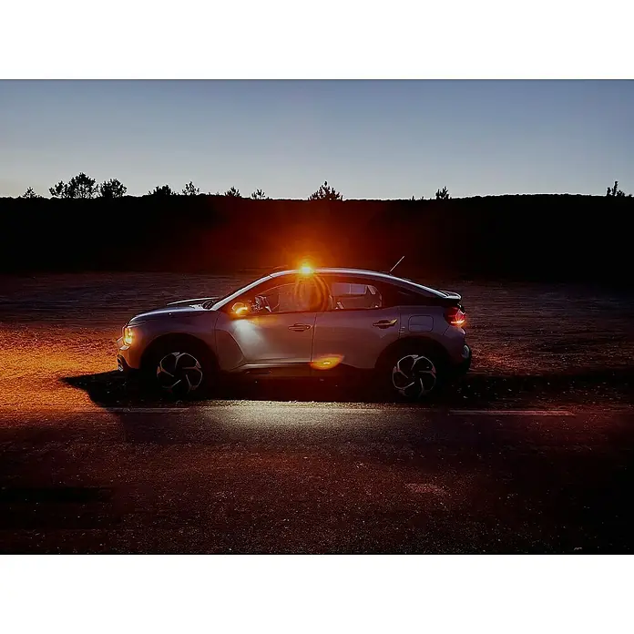 Luz de emergencia Help Flash IoT+ - Apto para: Avería en el vehículo - Vista lateral de un Citroen C4 plateado con las luces encendidas al anochecer, destacando su diseño moderno.