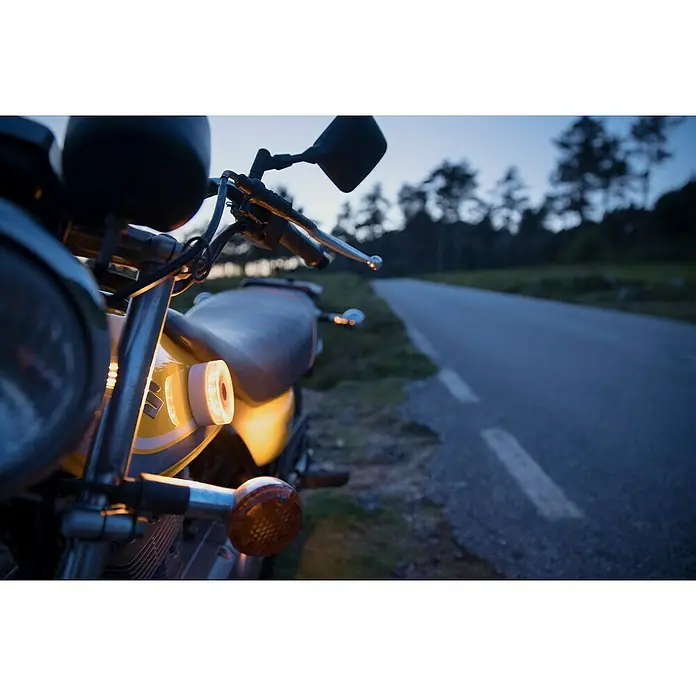 Luz de emergencia Help Flash IoT+ - Apto para: Avería en el vehículo - Primer plano de una moto con depósito amarillo y luces LED aparcada al borde de la carretera al atardecer. Énfasis en seguridad y visibilidad.