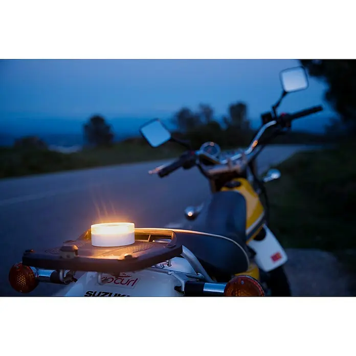 Luz de emergencia Help Flash IoT+ - Apto para: Avería en el vehículo - Una linterna LED brillante se sienta en el portaequipajes de una motocicleta Suzuki, la luz ilumina el entorno crepuscular creando ambiente.
