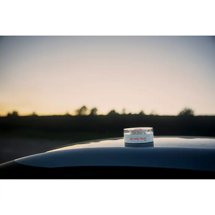 Luz de emergencia Help Flash IoT+ - Apto para: Avería en el vehículo - Primer plano de una luz de emergencia Help Flash IoT en el techo de un coche al atardecer, diseñada para mejorar la seguridad vial.