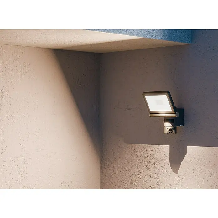 Steinel LED-Strahler CAM 2 SC - 21 W, 2.310 lm, 3.000 K, IP44 - Moderne Außenleuchte an einer Wand befestigt, die den Bereich mit hellem Licht erhellt und gleichzeitig für Sicherheit sorgt.