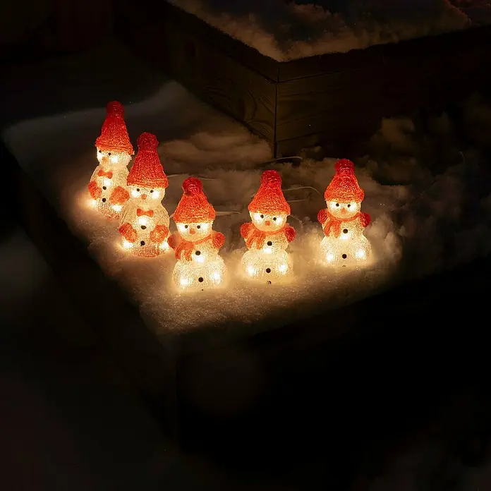 Konstsmide LED-Lichterkette Schneemänner - Innen, Lichtfarbe: Warmweiß, Anzahl Leuchtmittel: 40 Stk., Netzbetrieben - Eine Reihe von niedlichen leuchtenden Schneemannfiguren mit roten Hüten und Schals, die im Schnee aufgereiht sind und eine festliche Weihnachtsatmosphäre verbreiten.