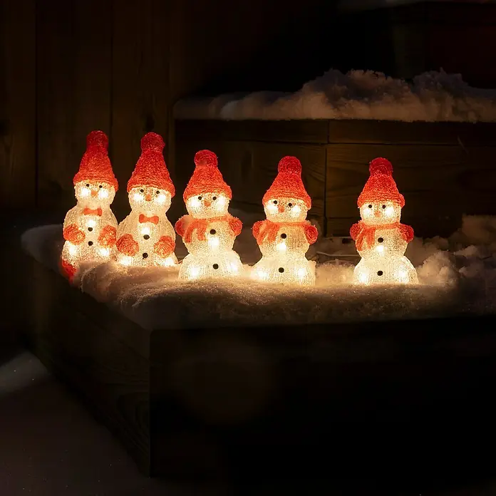 Konstsmide LED-Lichterkette Schneemänner - Innen, Lichtfarbe: Warmweiß, Anzahl Leuchtmittel: 40 Stk., Netzbetrieben - Leuchtende Schneemann-Figuren mit roten Mützen auf einer verschneiten Oberfläche, die festliche Stimmung verbreiten.
