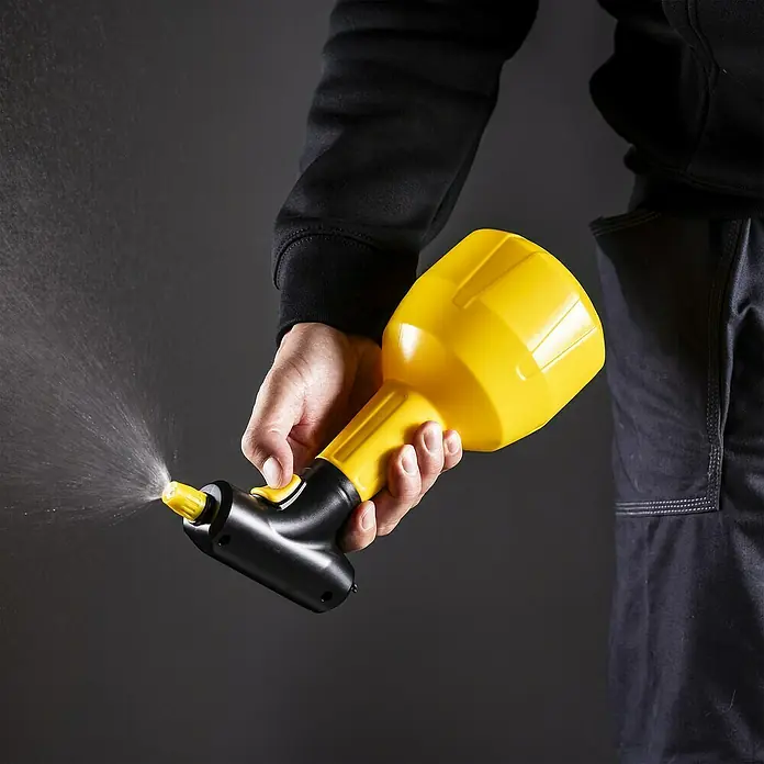 Mesto Handsprüher e.FLOWER 3,7 V - Gelb, 1 l - Die gelb-schwarze Sprühflasche wird von einer Person bedient, wobei deutlich ein feiner Sprühnebel austritt.