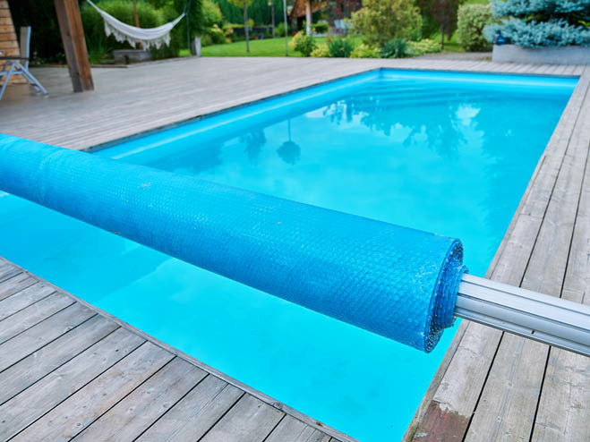 Aufgerollte Abdeckplane über dem Einbaupool mit Holzsteg