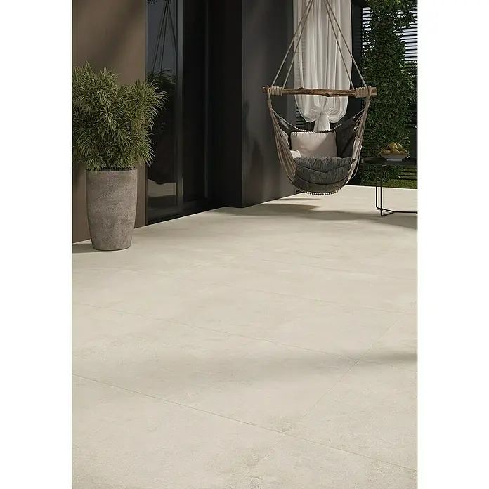 Queens Terrassenfliese - 59,3 x 119,3 x 2 cm, Beige, Matt - Terrassenansicht mit einem hängenden Stuhl, Pflanzenkübel und einem kleinen Tisch. Die hellen Bodenfliesen verleihen dem Außenbereich eine moderne Note.