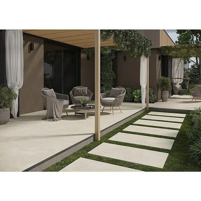 Queens Terrassenfliese - 59,3 x 119,3 x 2 cm, Beige, Matt - Terrassenbereich mit stilvollen Rattansesseln und einem kleinen Tisch, umgeben von üppigem Grün.