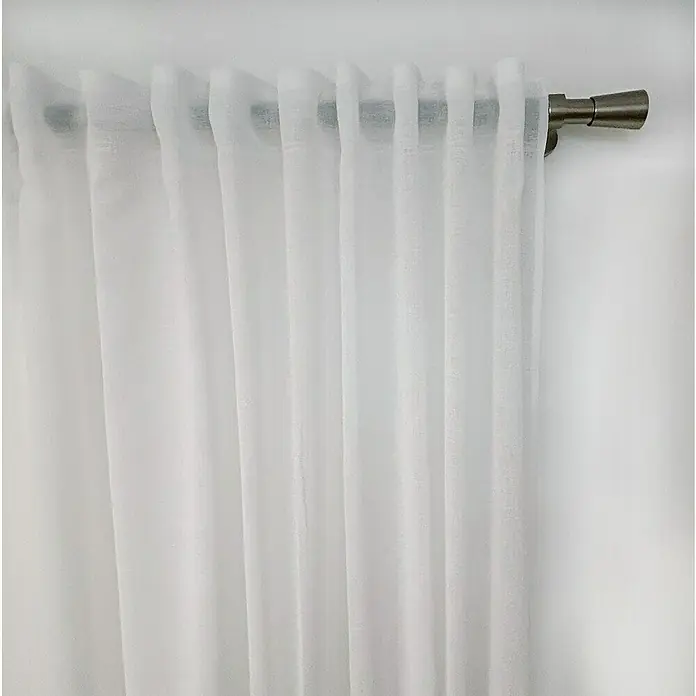 Visillo para ventana Cinta Multifunción Catina - An x Al: 140 x 270 cm, 100% poliéster, Blanco - Un primer plano de elegantes cortinas blancas colgando de una moderna barra de metal, creando una iluminación suave y difusa.