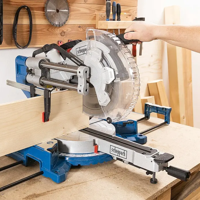 Scheppach Kapp- & Gehrungssäge HM305SL - 2.000 W, Durchmesser Sägeblatt: 305 mm, Leerlaufdrehzahl: 5.000 U/min - Eine Scheppach Kapp- und Gehrungssäge beim Zuschneiden eines Holzstücks, ideal für präzise Holzarbeiten in der Werkstatt.