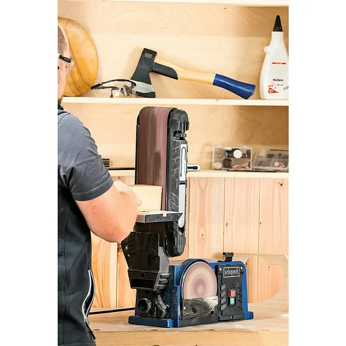 Scheppach Lijadora de banda y disco BTS900 - 370 W, 2.850 r.p.m. - Primer plano de una lijadora de banda Scheppach BTS800 lijando un trozo de madera en un taller.