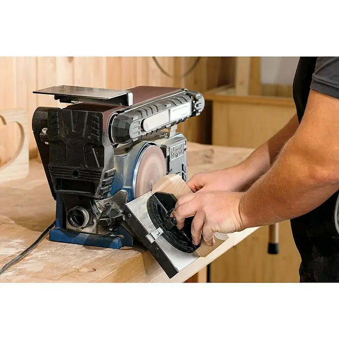 Scheppach Lijadora de banda y disco BTS900 - 370 W, 2.850 r.p.m. - Primer plano de un hombre lijando una pieza de madera en una lijadora de disco de banda Scheppach BTS800.