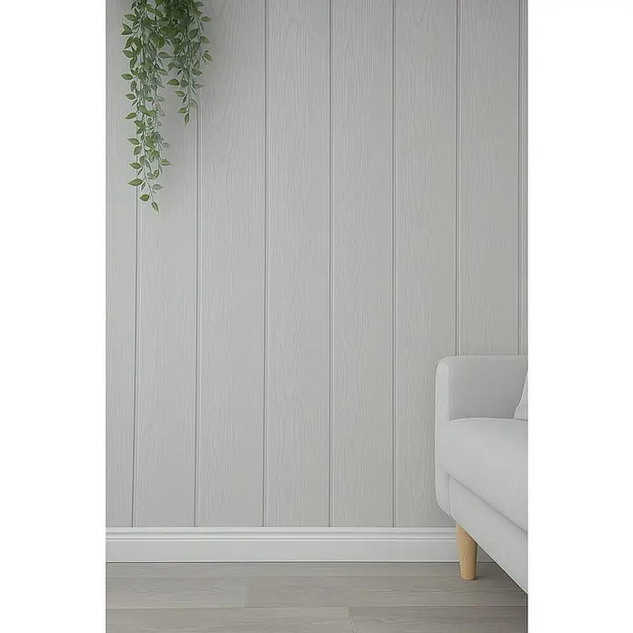 Panel de pared Fresno - 2.600 x 154 x 10 mm - Pared de paneles de madera clara con una planta de interior decorativa y parte de un sofá blanco, creando un ambiente acogedor en la habitación.