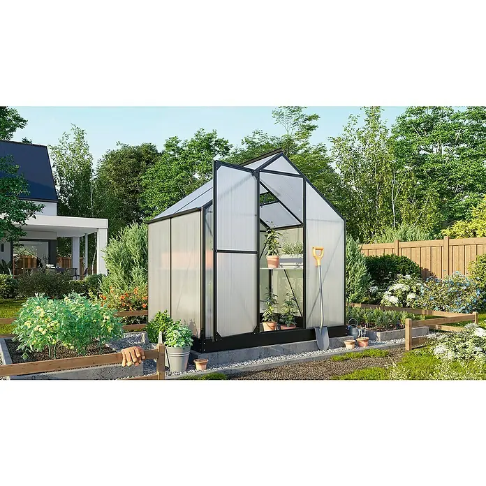 Vitavia Gewächshaus Eos 3100 - 6 mm - Ein Gewächshaus mit geöffneter Tür, umgeben von üppigem Grün und einem gepflegten Garten, bietet den perfekten Raum für Pflanzenliebhaber.