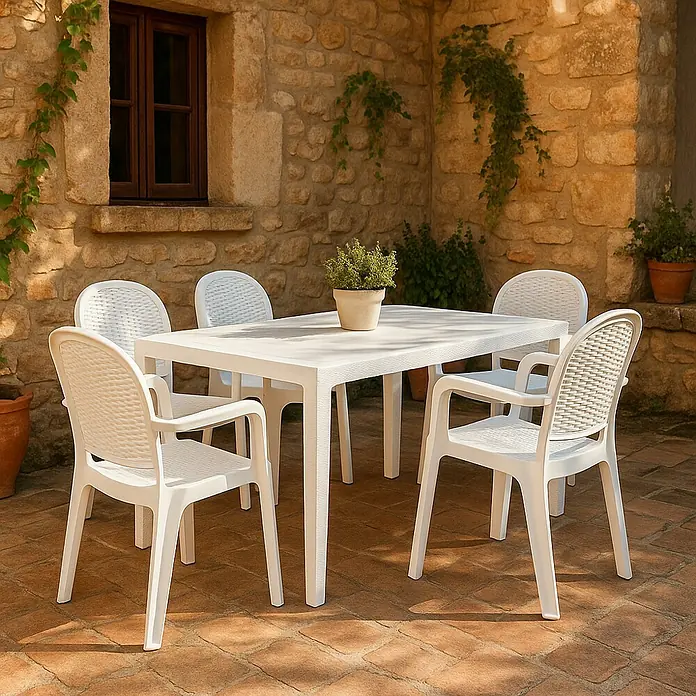 Mesa de jardín Lasarte - L x An x Al: 150 x 90 x 72 cm, Tecnopolímero/Fibra de vidrio, Blanco - Conjunto de muebles de jardín blanco con una mesa y cuatro sillas, situado en un patio pavimentado con pared de piedra al fondo.