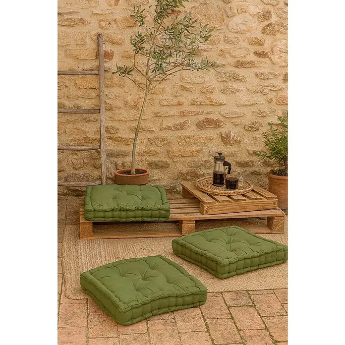 Cojín para suelo capitone water resist - 45 x 45 cm, Verde - Cojines de suelo verdes en un entorno rústico al aire libre con pared de piedra y escalera de madera, ideales para relax.