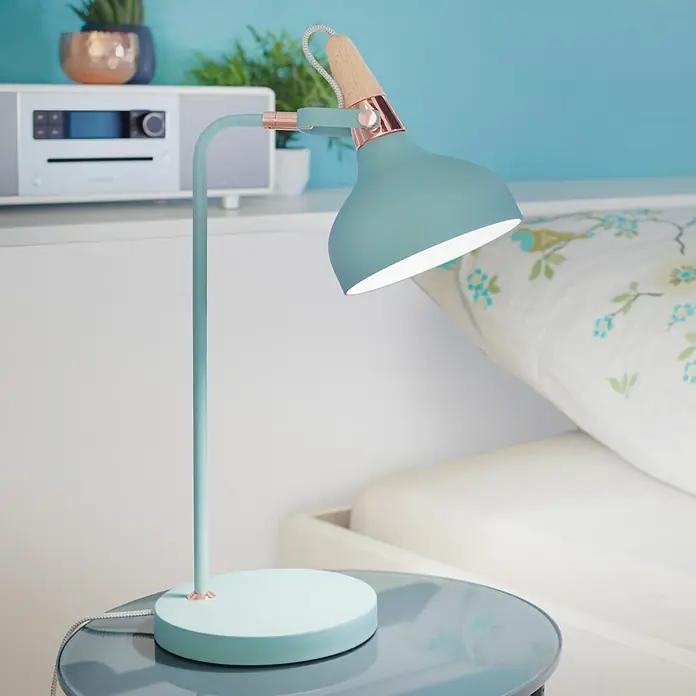 Paulmann Neordic Tischleuchte Juna - 20 W, Softgrün, E14 - Nahaufnahme einer modernen, türkisblauen Schreibtischlampe mit Kupferdetails auf einem Nachttisch.