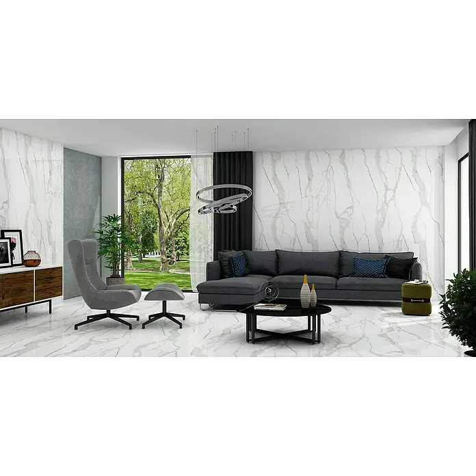 Momastela Feinsteinzeugfliese Calacatta Gold Matt - Weiß/Grau/Gold, Matt, L x B x S: 60 x 120 x 0,9 cm - Das Bild zeigt ein modernes Wohnzimmer mit einer grauen Couch, einem Sessel und einem Couchtisch, beleuchtet von einer modernen Lampe.