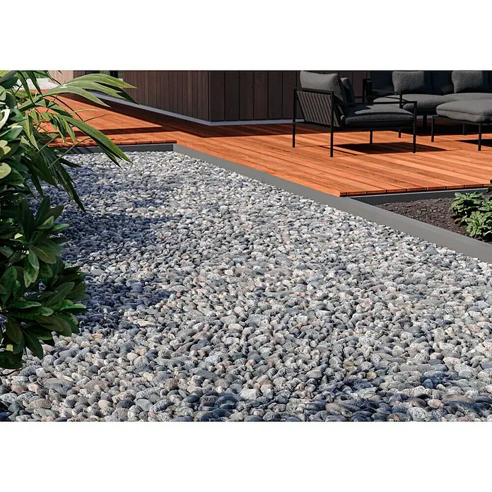 Leintrade Bindemittel für Kieselsteine - 10 l - Kiesweg neben einer Holzterrasse mit Gartenmöbeln. Der Kies ist grau und liegt dicht an dicht.