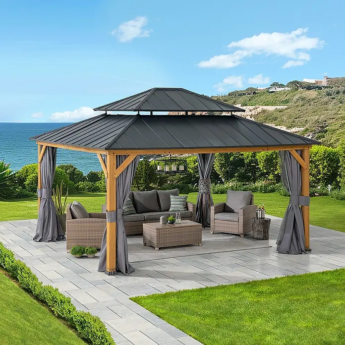 Sunjoy Pavillon Trivor - L x B: 390 x 450 cm, Farbe Dach: Anthrazit - Elegante Gartenlaube mit Möbeln auf einer Terrasse, ideal für entspannte Stunden im Freien. Das dunkle Dach bietet Schutz vor Sonne und Wetter.