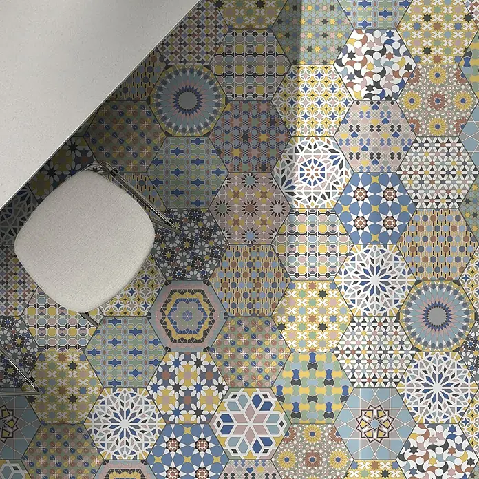 Feinsteinzeugfliese Hexagon Kasbah Mixed - 25 x 22 cm, Bunt, Matt - Bunter Boden mit sechseckigen Fliesen in verschiedenen Mustern und Farben, dazu ein Stuhl.