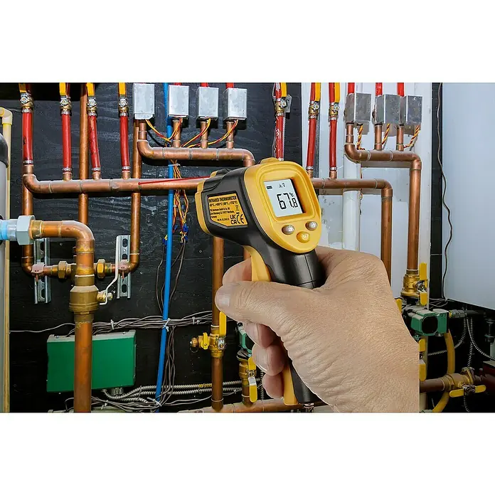 TFA Dostmann Infrarot-Thermometer RAY LIGHT - Messbereich Temperatur: -50 °C - 400 °C - Nahaufnahme eines gelben und schwarzen Infrarot-Thermometers, das 67,8 Grad Celsius an einer Rohrleitung anzeigt.