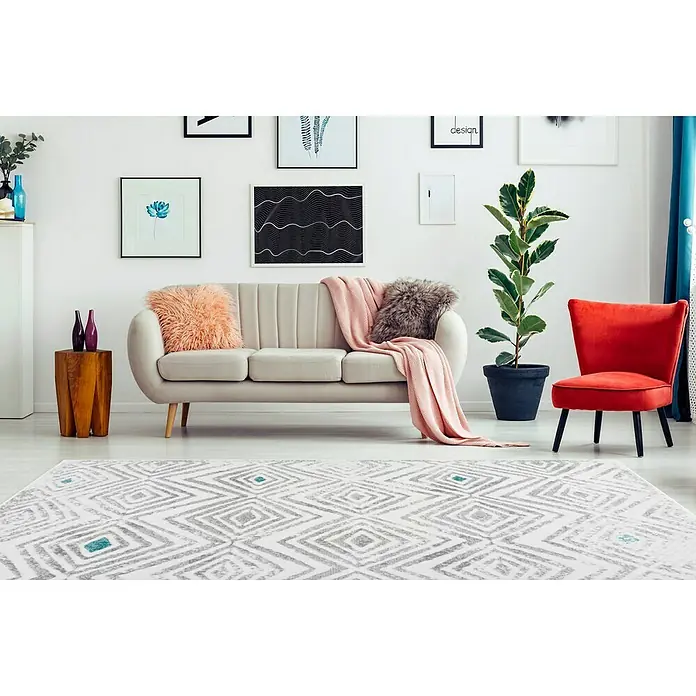 Kayoom Kurzflorteppich Vancouver 410 - Weiß/Grau, 150 x 80 cm, 100 % Polypropylen - Ein helles Wohnzimmer mit einem stilvollen Teppich mit geometrischem Muster, der dem Raum einen modernen Touch verleiht.