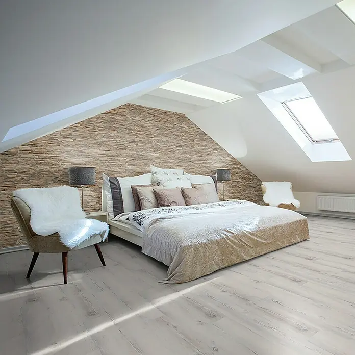 Indo Wandpaneel 3D Wall Diamondwood Ancient Grey - Teak, 610 x 150 x 10 mm, 1,006 m² - Helles Schlafzimmer mit Steinwand, Dachfenstern und einem bequemen Bett mit vielen Kissen. Elegantes Interieur für erholsame Nächte.