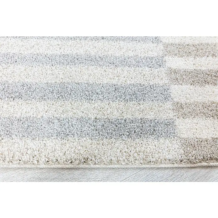 Alfombra de pelo largo Rayas - Natural, 230 x 160 cm, 100% Polipropileno - Primer plano de una alfombra con rayas horizontales en tonos blancos y grises, mostrando una textura suave.