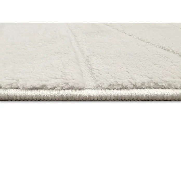 Alfombra de pelo corto Stelvio Olas - Crudo, 200 x 140 cm, 100% Poliéster - Primer plano de una alfombra blanca y suave con un borde texturizado que irradia confort y calidez para cualquier habitación.