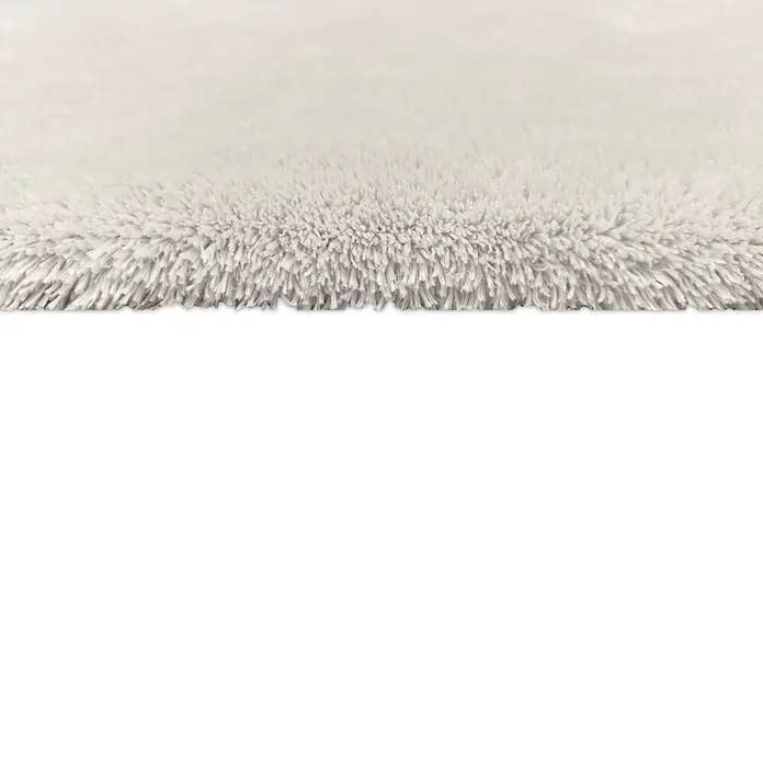 Alfombra de pelo largo Cuba - Blanco, 60 x 110 cm, 100% Poliéster - Primer plano de una alfombra suave y blanca que muestra una textura acogedora y un tacto suave. Ideal para salones y dormitorios.