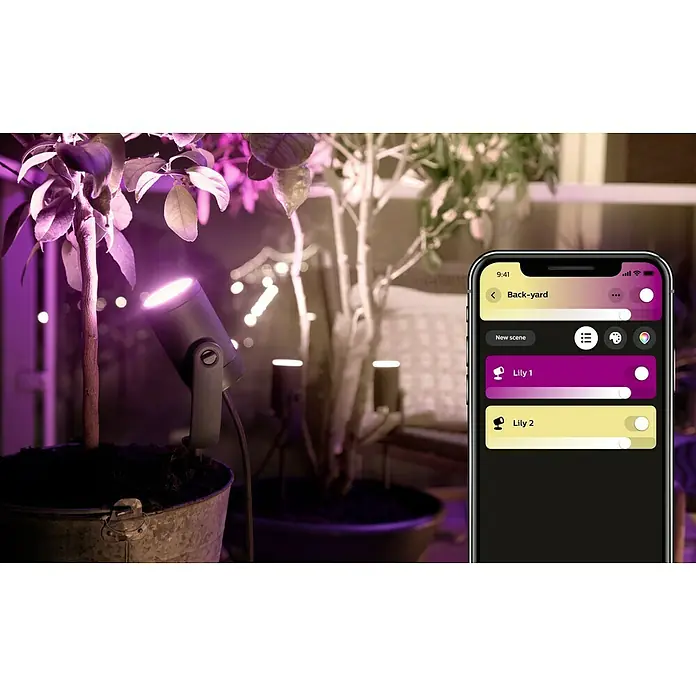 Philips Hue LED-Gartenspot Lily - 8 W, Lichtfarbe: RGB, IP65 - Intelligente Philips Hue Lily Gartenstrahler in Szene gesetzt, gesteuert per Smartphone-App, für stimmungsvolle Beleuchtung im Außenbereich.