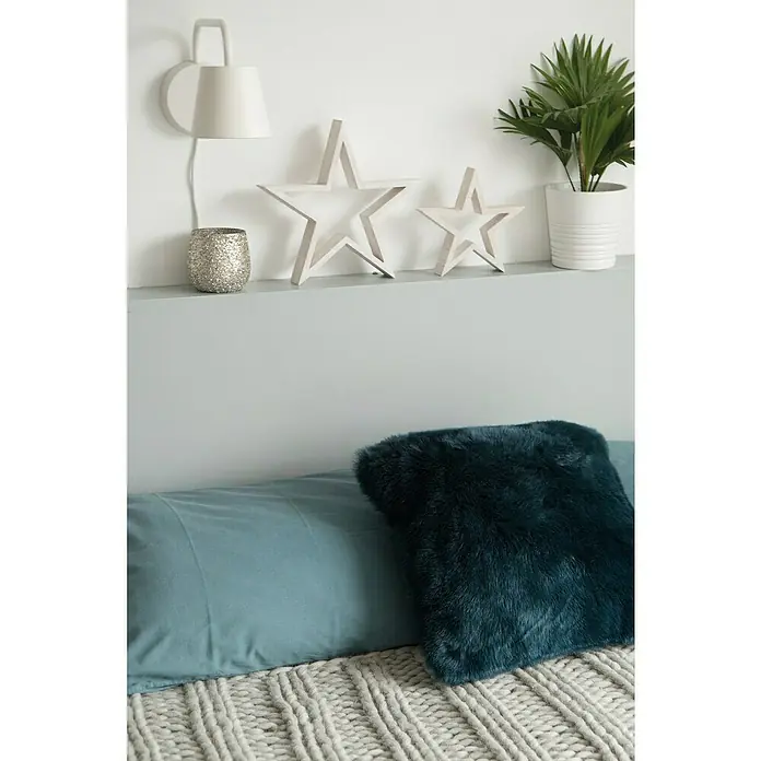 D-c-fix Klebefolie Uni Seidenmatt - 200 x 67,5 cm, Hellgrau, Selbstklebend - Nahaufnahme eines Bettes mit blauem Kissen und Pelzkissen, dekoriert mit Sternen und einer Lampe auf dem Nachttisch.