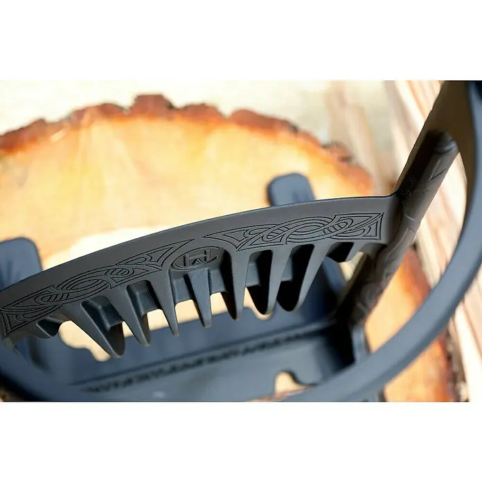 Kindling Cracker Holzspalter Original - Max. Spaltgutdurchmesser: 16 cm - Nahaufnahme eines schwarzen Holzspalters mit Verzierungen vor einem Baumstammschnitt.