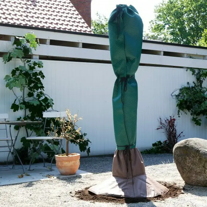 BioGreen Winterschutz Stammschutz für Palmen - Passend für: Stammdurchmesser bis 35 cm - Ein grüner Winterschutzsack umhüllt einen Baum im Garten, der vor Kälte und Frost schützt. Ideal für den Winter.