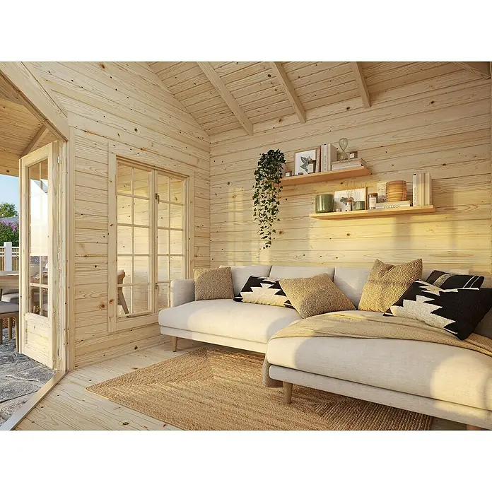 Palmako Caseta de jardín Melanie - Medidas ext. (An x Pr): 599 x 322 cm, Madera, Natural, 20 m² - Luminosa sala de estar en una casa de madera con sofá, estanterías y ventanas, creando una sensación de calidez y elegancia natural.