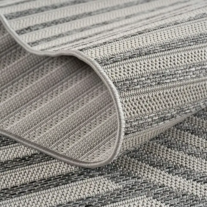 Outdoor-Teppich Desert 1301 - Grau, 230 x 160 cm, 100 % Polypropylen - Detailansicht eines grau gestreiften Teppichs mit gewebter Textur und sauber eingefasstem Rand.