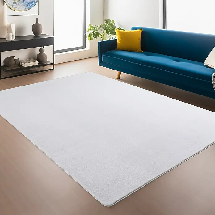 Kurzflorteppich Joy - Weiß, 280 x 200 cm, 100 % Polyester - Ein weißer Teppich liegt im Wohnzimmer und strahlt schlichte Eleganz aus. Er ergänzt das blaue Sofa und die moderne Einrichtung perfekt.