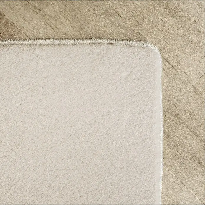 Kurzflorteppich Joy - Creme, 280 x 200 cm, 100 % Polyester - Nahaufnahme eines cremefarbenen Teppichs mit sauberem Rand auf einem hellen Holzboden, der die Textur und die sanften Farben hervorhebt.