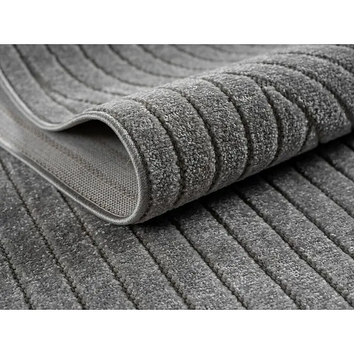 Outdoor-Teppich Nova I - Silver, Durchmesser: 80 cm, 100 % Polypropylen - Nahaufnahme eines gerollten, grau gestreiften Teppichs, der die Textur und das Design hervorhebt. Perfekt für moderne Wohnräume und Fußbodenbeläge.