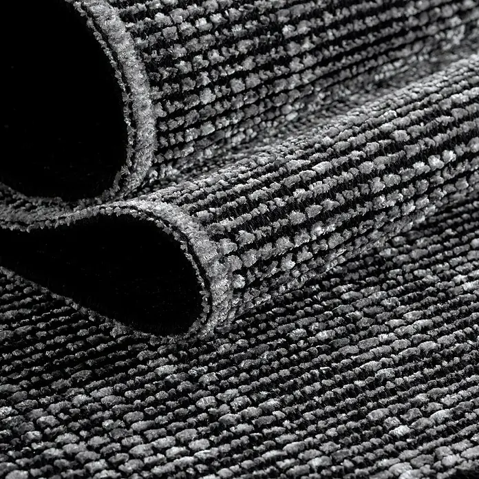 Flachgewebeteppich Space - Grau, 230 x 160 cm, 84 % Baumwolle, 16 % Polyester - Detailaufnahme eines gerollten grauen Teppichs mit einem feinen Streifenmuster, das Textur und Tiefe zeigt.\n
